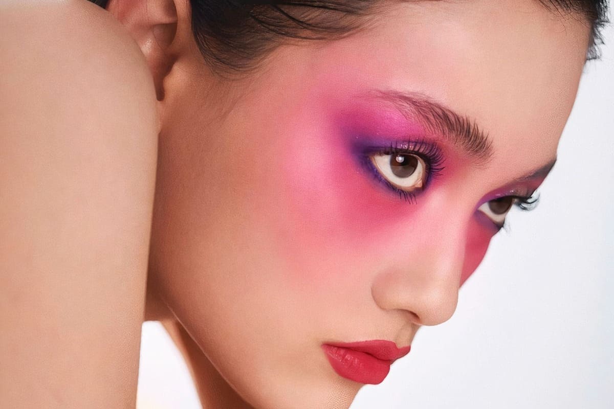 modella con trucco scenografico, blush sugli occhi e rossetto rosso