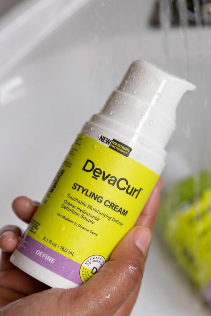 Devacurl Styling Cream in mano su lavandino