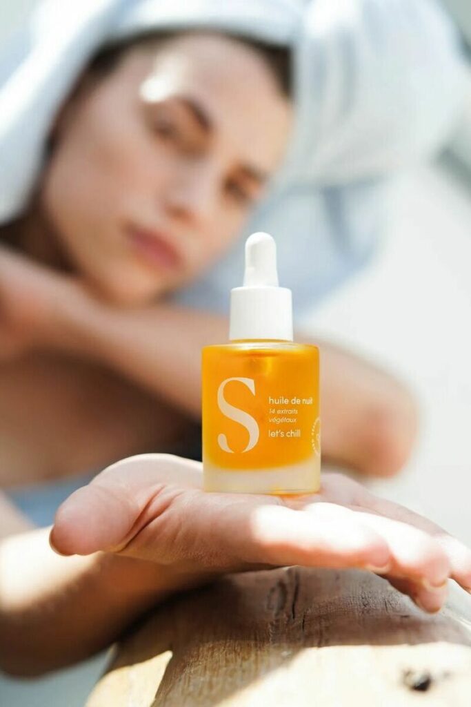 ragazza sullo sfondo tiene in mano olio viso notte di Seasonly