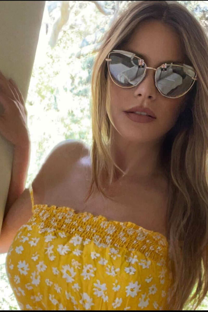 Sofia Vergara occhiali da sole specchiati e minidress giallo a fiorellini