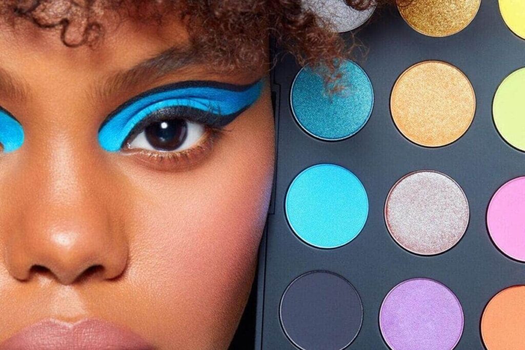 primo piano su make-up grafico azzurro e palette ombretti colorati