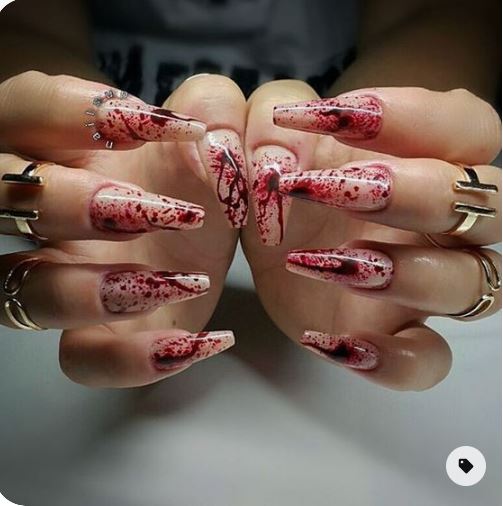 mani di ragazze con unghie lunghe color nude e rosse a rappresentare il sangue