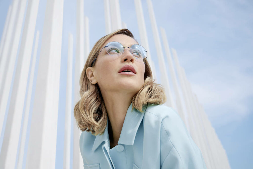 Donna con occhiali da vista senza montatura e lenti azzurre e camicia azzurra