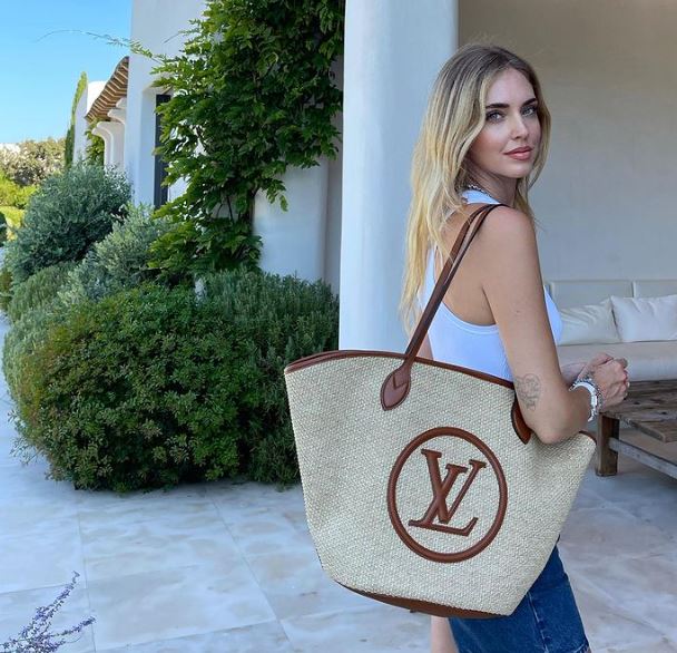 ragazza con indosso una borsa louis vuitton in paglia 