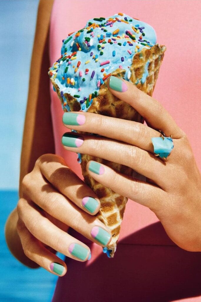 primo piano di ragazza con gelato tra le mani e unghie colorate - Ice Cream Manicure tendenza unghie gelato