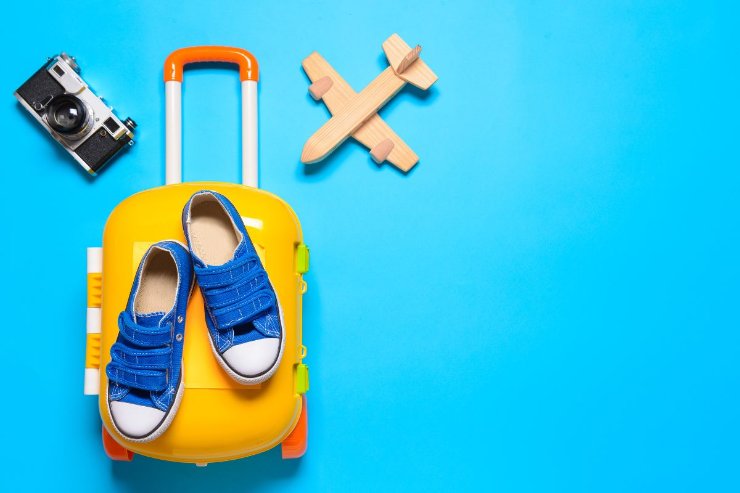 valigia, aeroplano di legno e scarpe estive