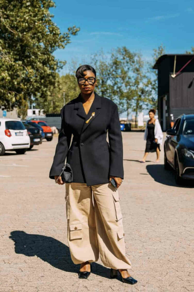 donna con giacca nera oversize e pantaloni cargo beige con tasche