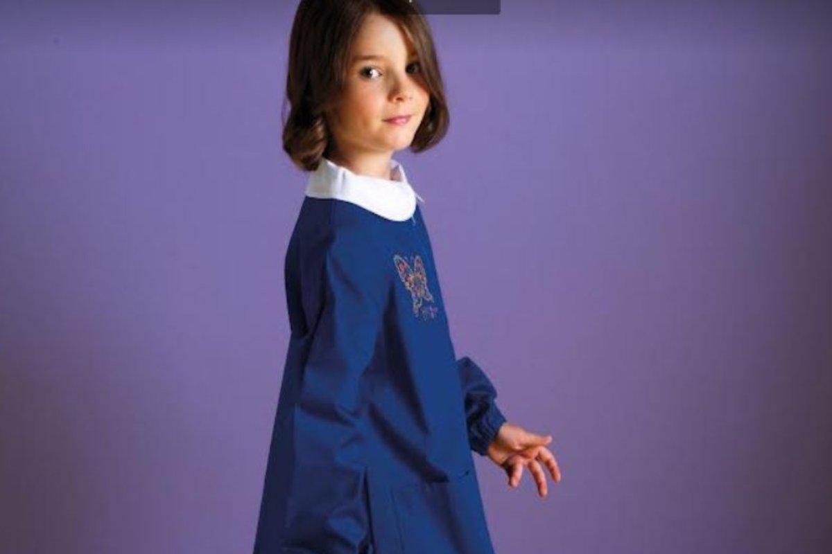 Bambina con un grembiule blu
