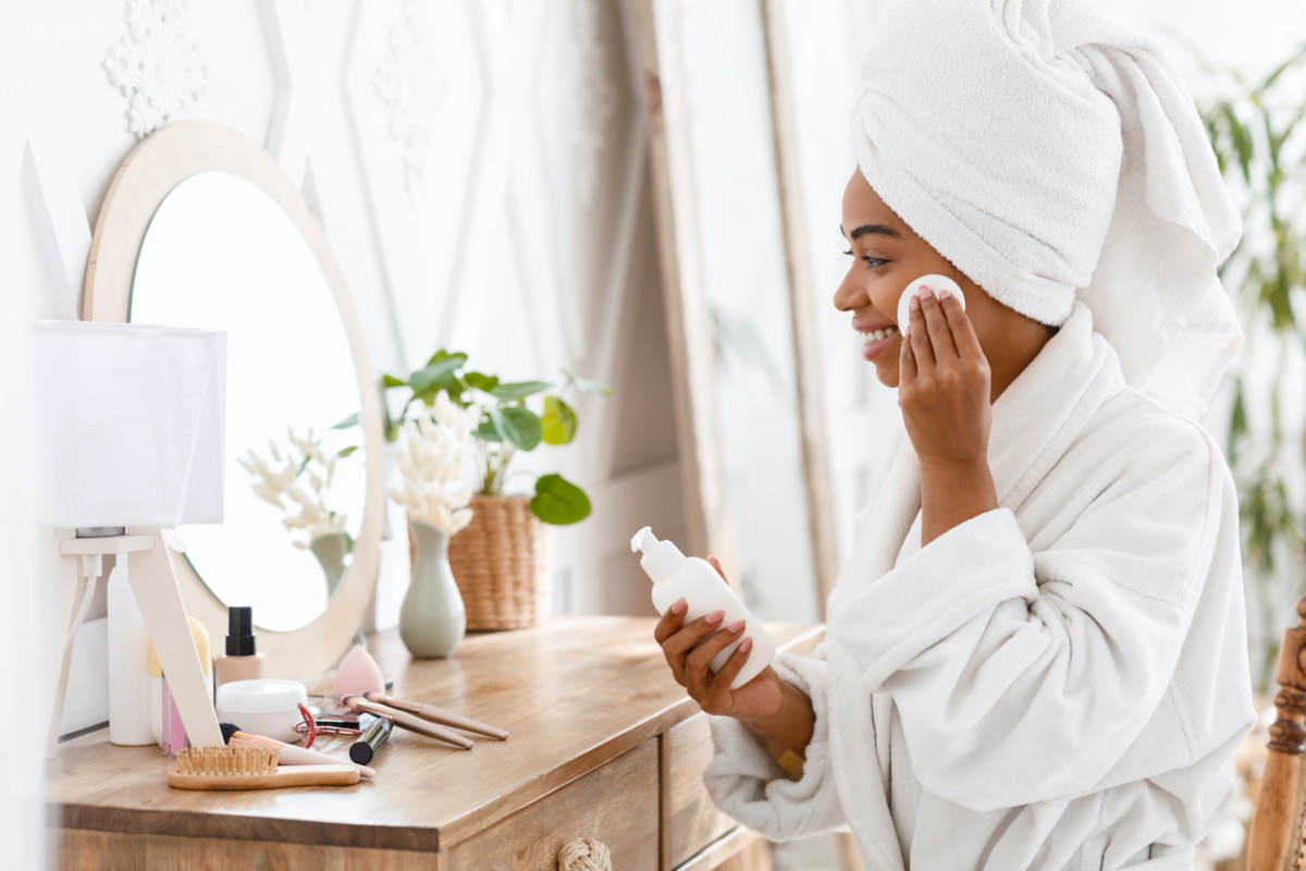 donna allo specchio prodotti bellezza skincare