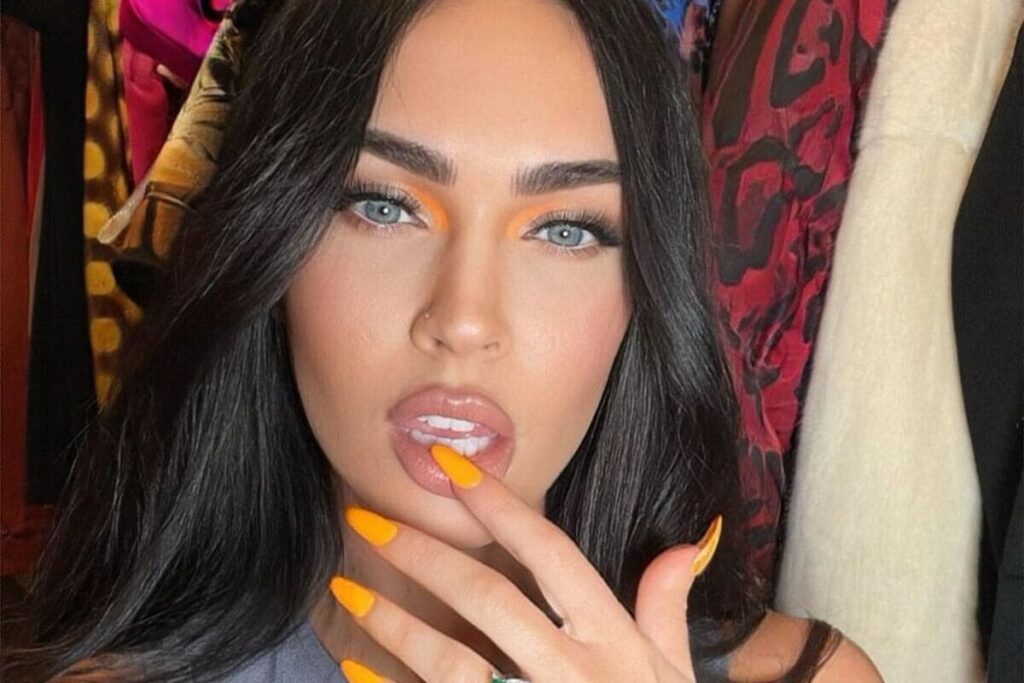 Megan Fox con unghie arancioni-colori smalto che esaltano l'abbronzatura