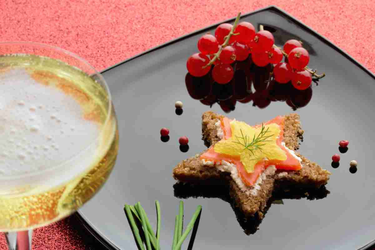 Tartine al salmone a forma di stella in un piatto nero lucido