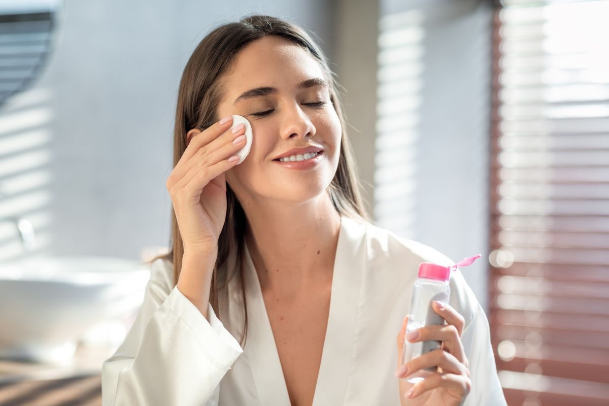 ragazza che si strucca con acqua micellare
