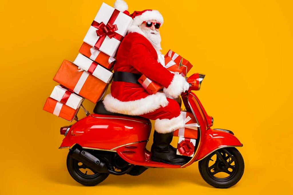 babbo natale con regali guida la vespa