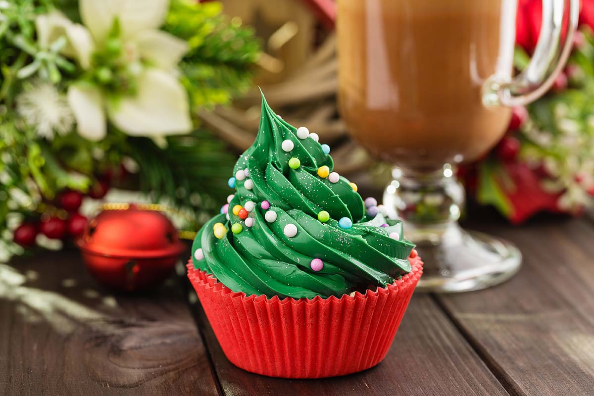Primo piano di un cupcake di Natale con pirottino rosso e frosting verde