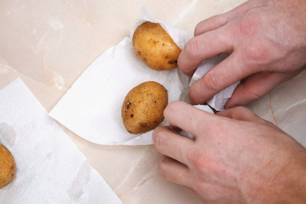 Uomo che avvolge delle patate in un tovagliolo