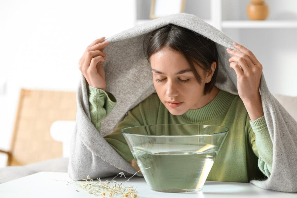 Ragazza che sta facendo i vapori con un asciugamano sulla testa