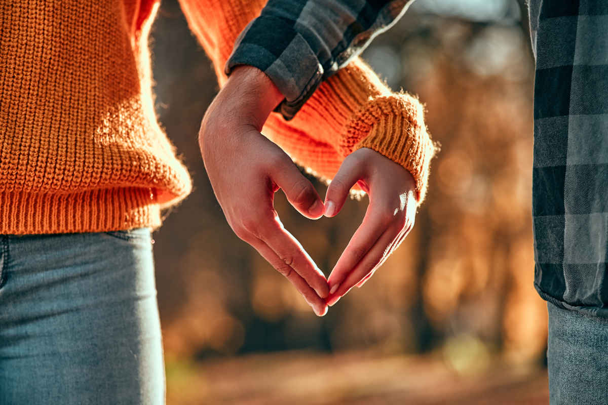 Coppia che intreccia le mani a forma di cuore