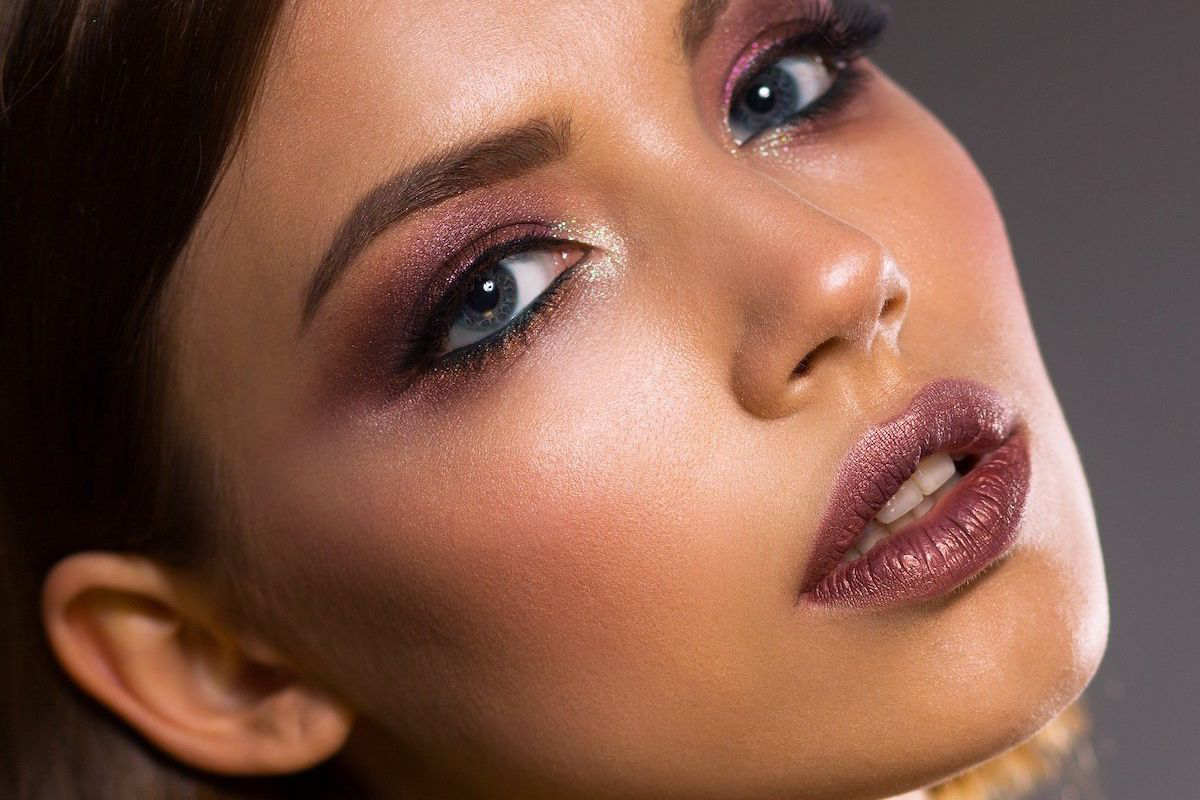 donna che si trucca con rossetto rosso e makeup occhi