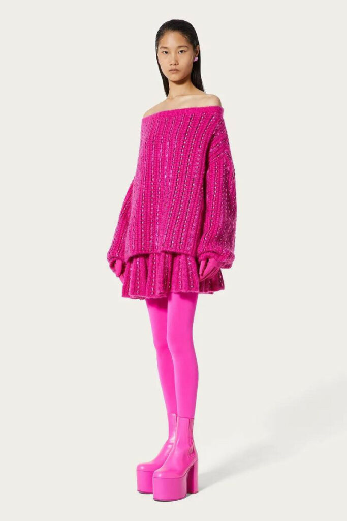 modella in maglione e gonna in lana rosa Valentino