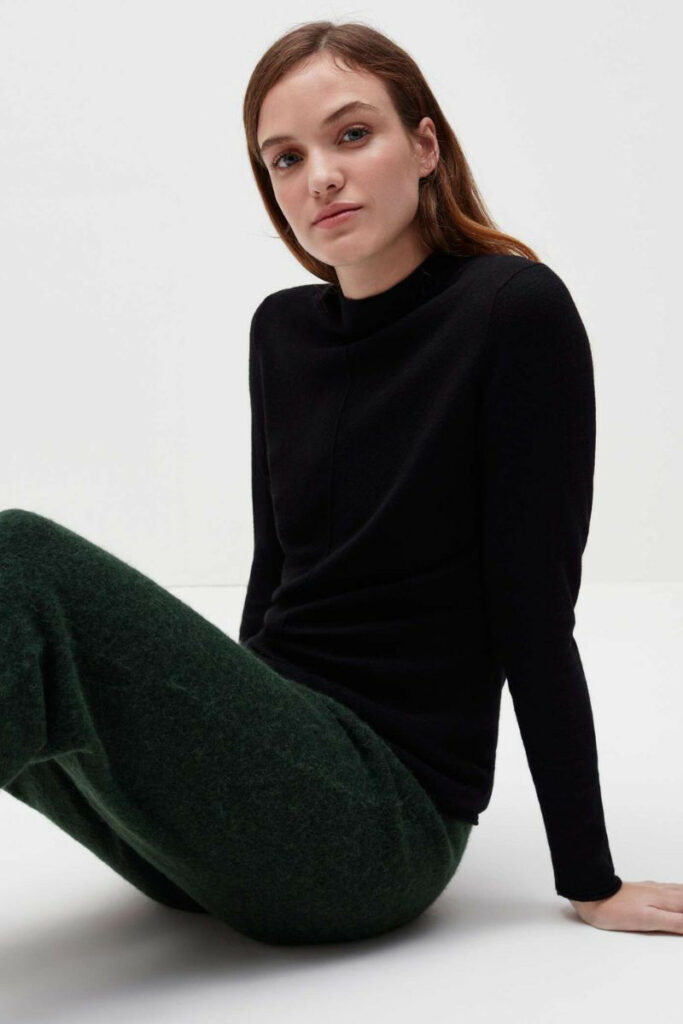 donna con pullover nero e pantaloni verde scuro