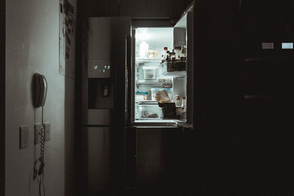 Frigo aperto di notte e pieno di cibo