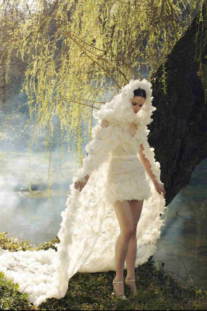 Modella con abito da sposa corto e velo con strascico 