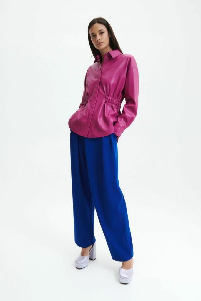 modella con camicia pelle fucsia e pantaloni blu elettricoreserved