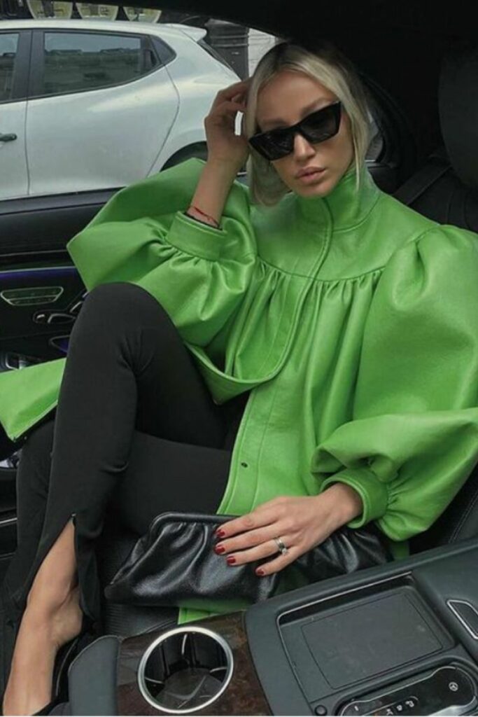 donna con camicia verde in pelle e leggins con spacco