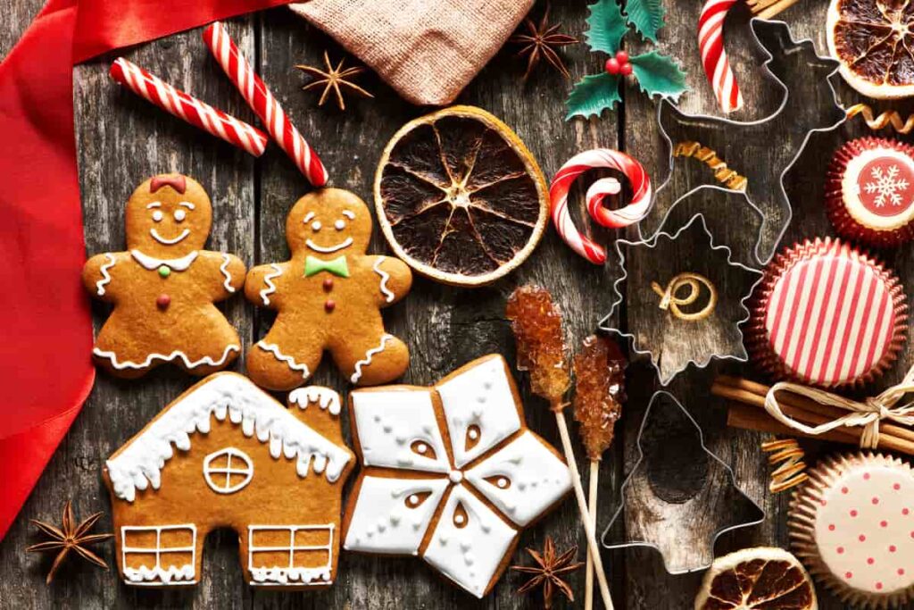 dolci biscotti natalizi a forma di casetta e stella su tavola di legno