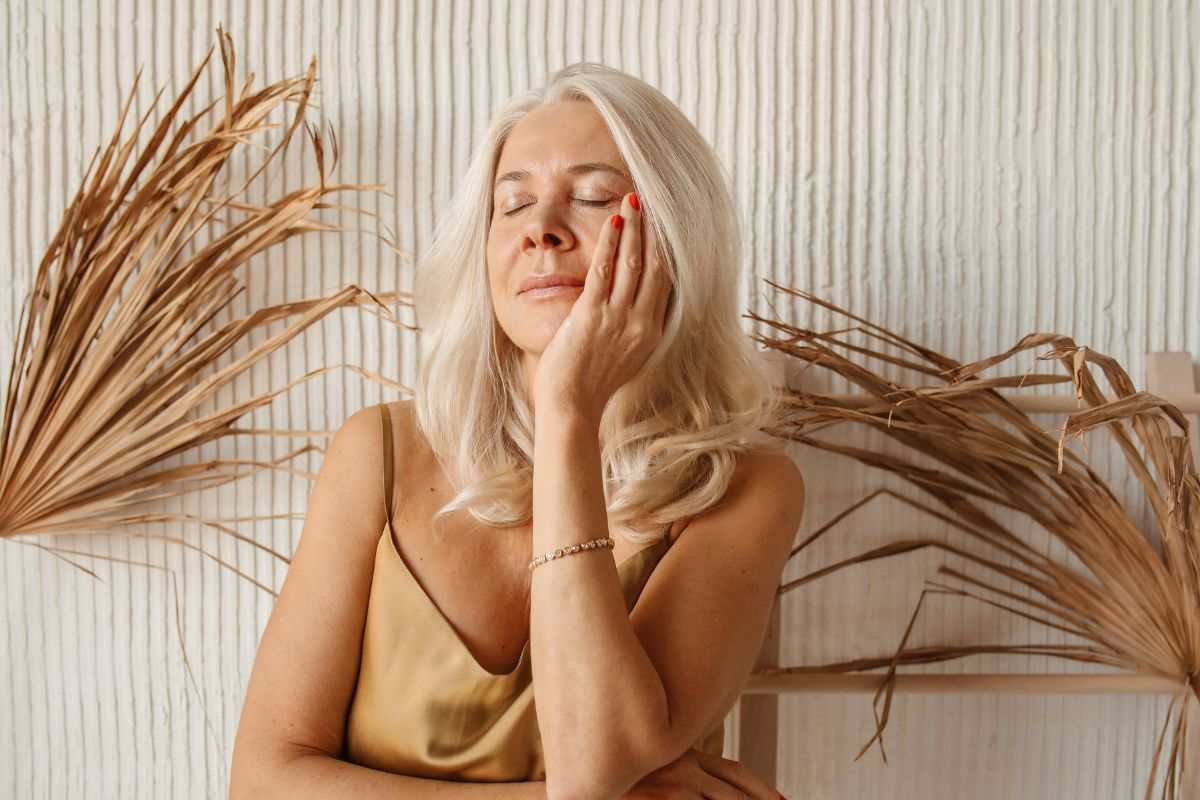 donna che si tocca il viso con la mano