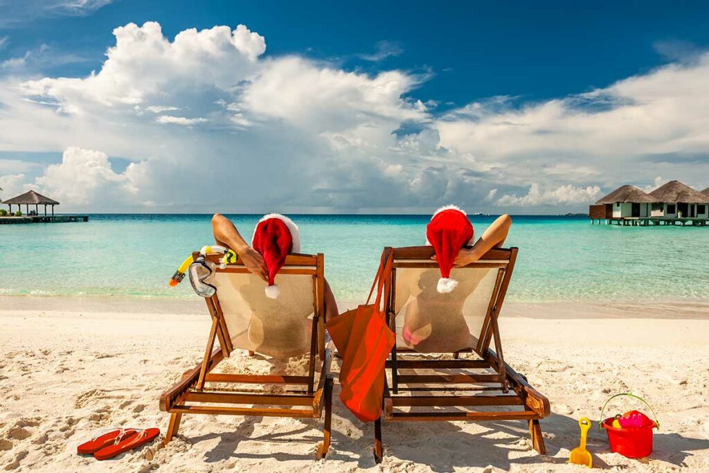 girls at tropical beach with christmas hat