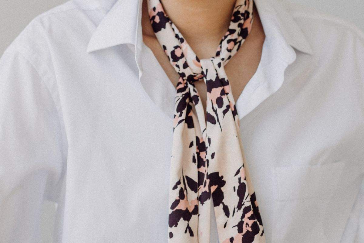 persona che indossa camicia bianca e cravatta animalier