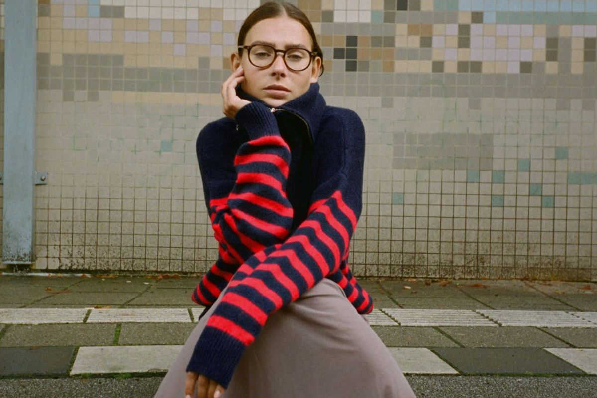 donna con maglione con zip a righe blu e rosso