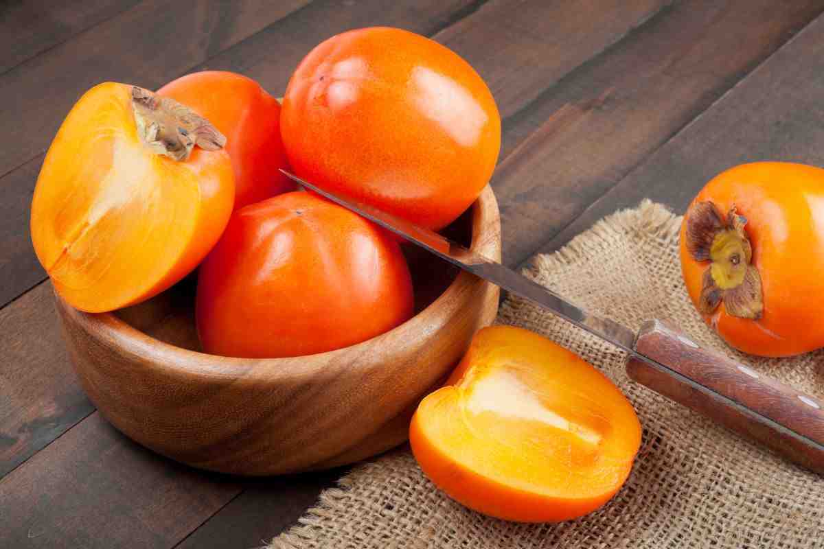 semi di cachi su tovagliolo e seme aperto con posata