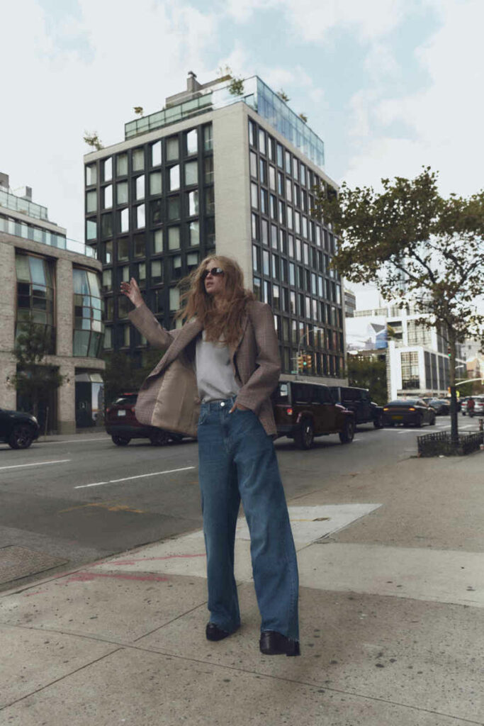 donna in città con jeans a palazzo e blazer
