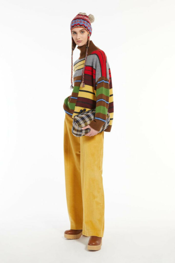 donna con pantaloni gialli in velluto e pullover multicolor
