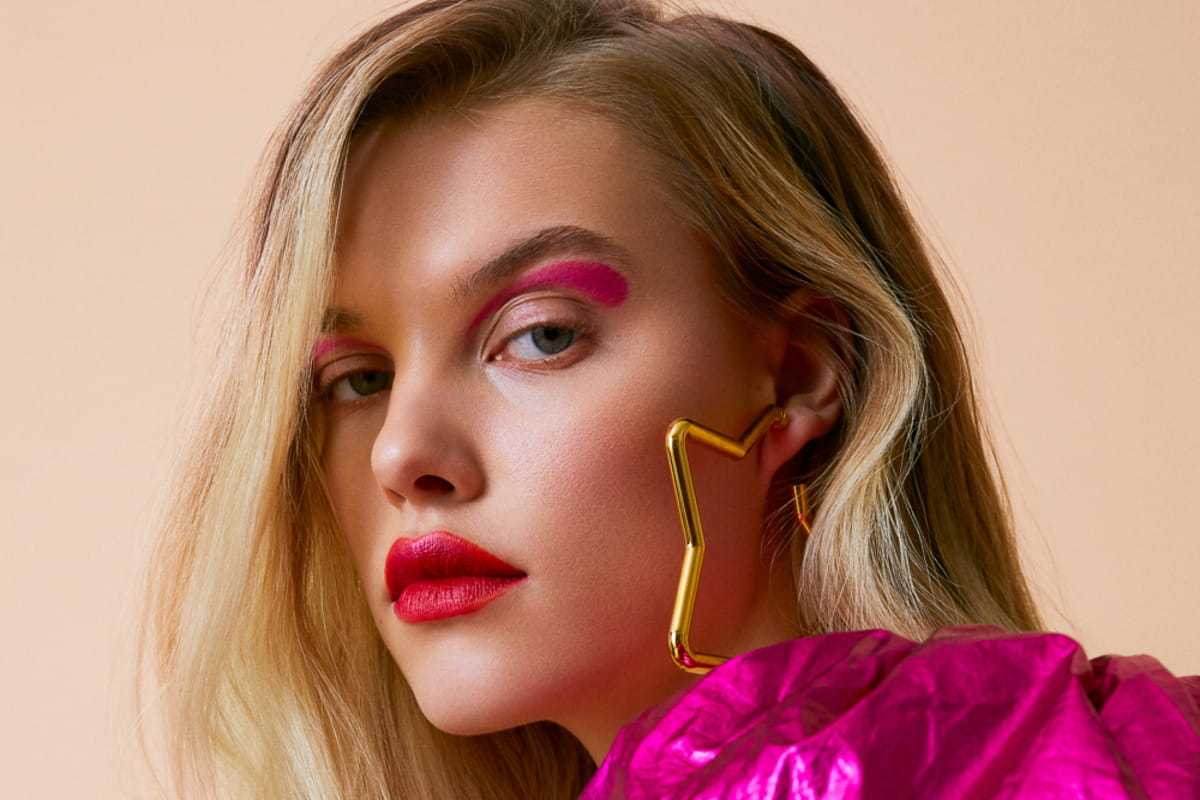 Modella con make-up fucsia e labbra glossate ciliegia