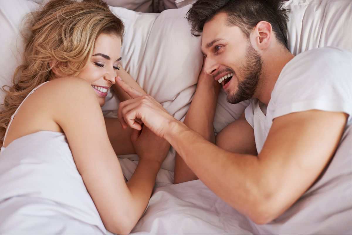 coppia nel letto che si accarezza il viso