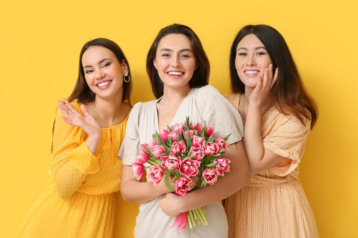 3 donne in posa con mazzo di fiori in mano
