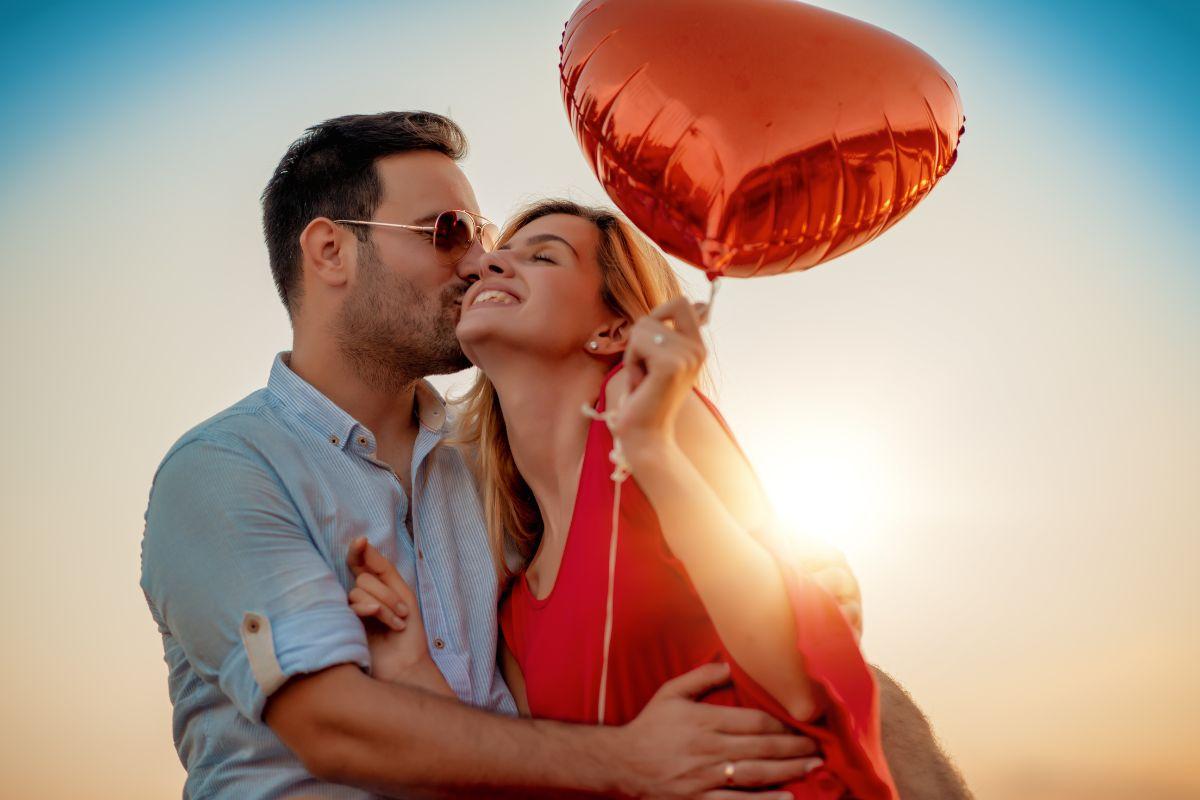 coppia felice con palloncino a forma di cuore in mano