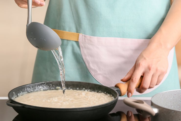 preparazione del risotto con zucchine e stracchino