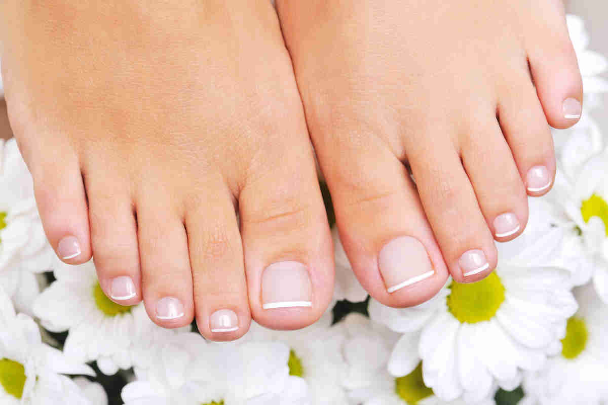 Piedi curati con unghie smaltate con french manicure