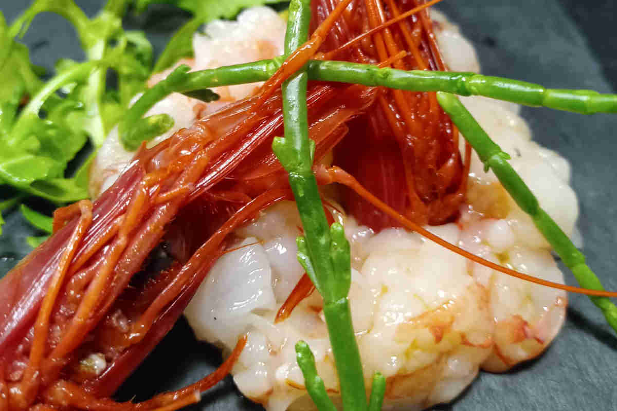 Tartare di gambero rosso di Mazara del Vallo con salicornia e rucola su piatto di ardesia