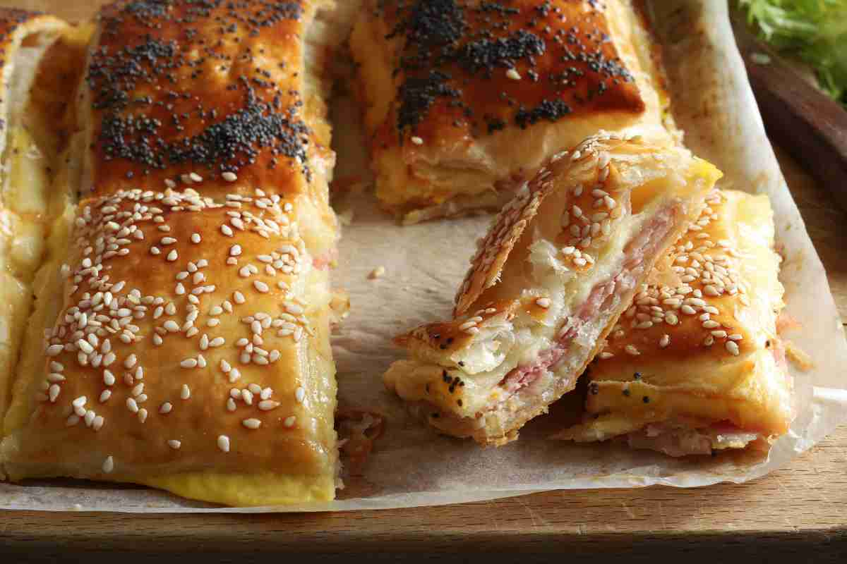 Torta con pasta sfoglia prosciutto e mozzarella, ricetta veloce di antipasto sfizioso