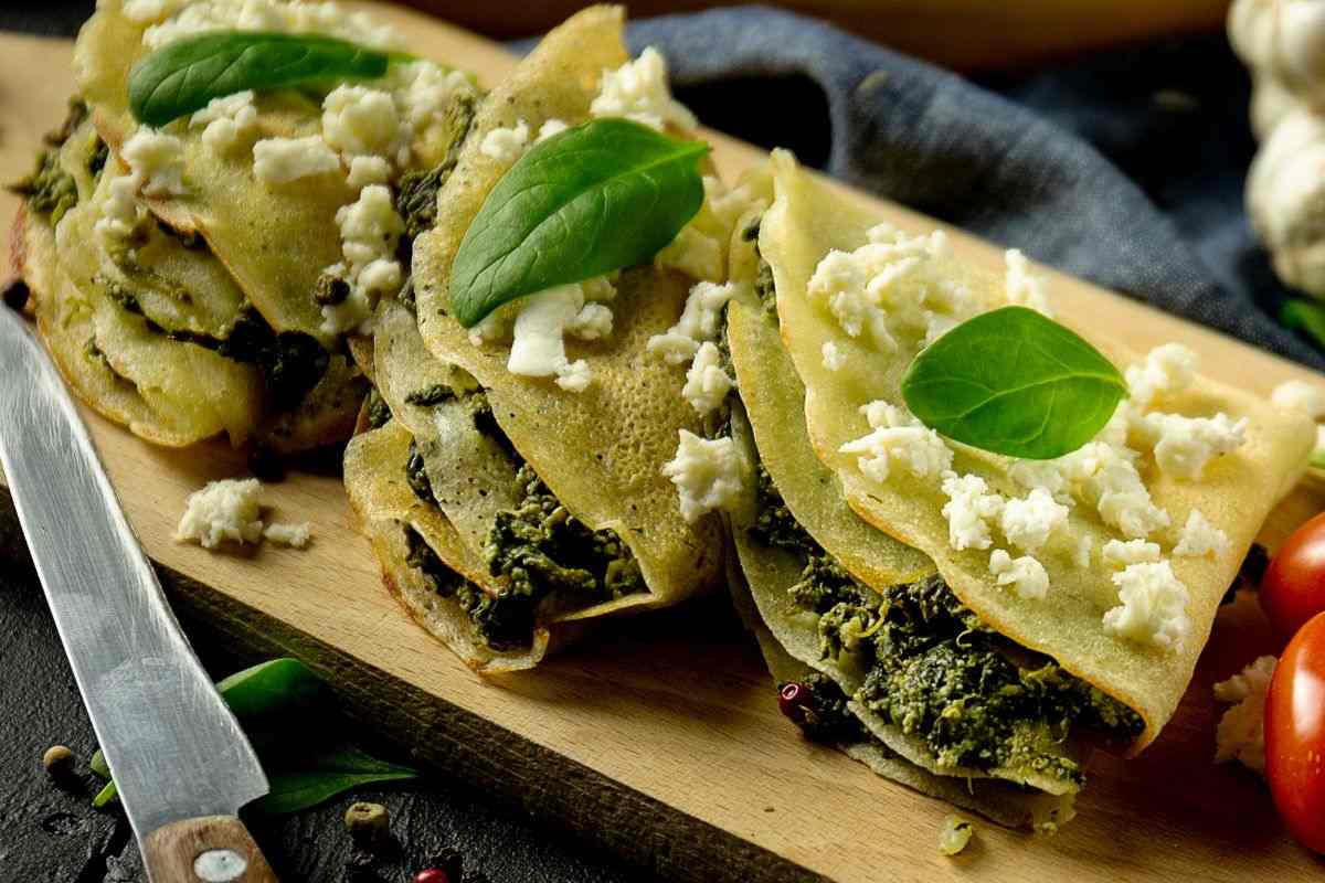 crespelle ricotta e spinaci su tagliere con altri ingredienti