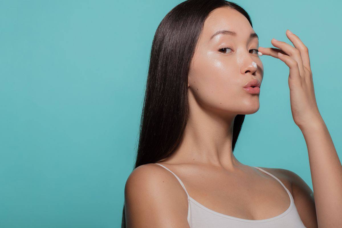 ragazza che applica crema sul viso