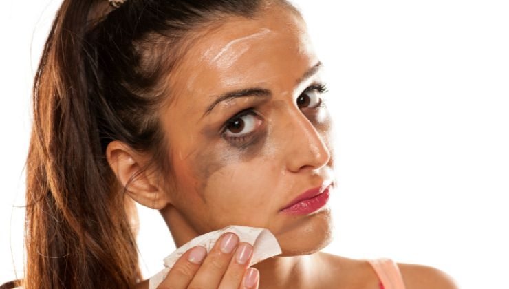 Ragazza che rimuove trucco ma macchia il viso