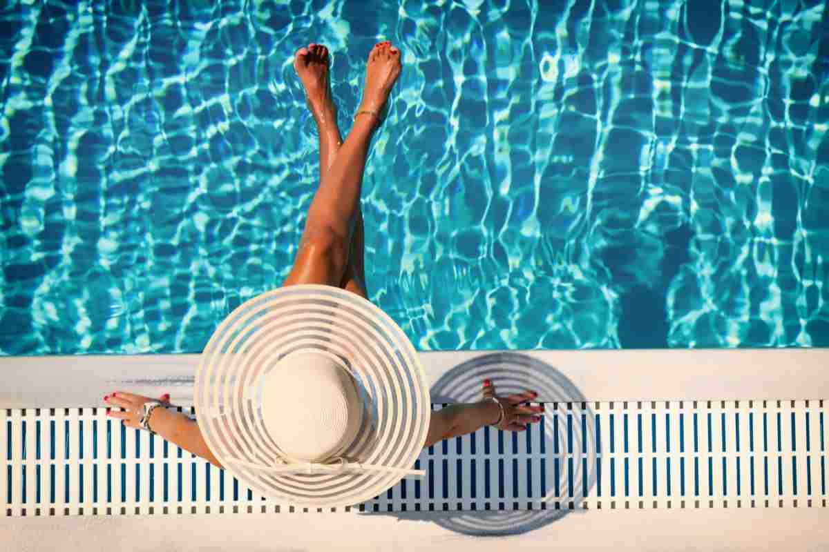 ragazza in piscina con cappello bianco