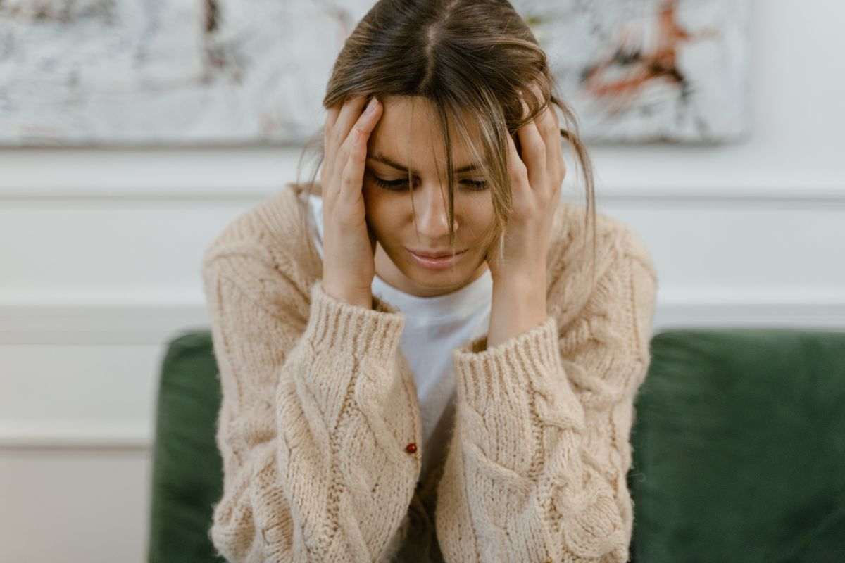 ragazza pensierosa con mani tra i capelli