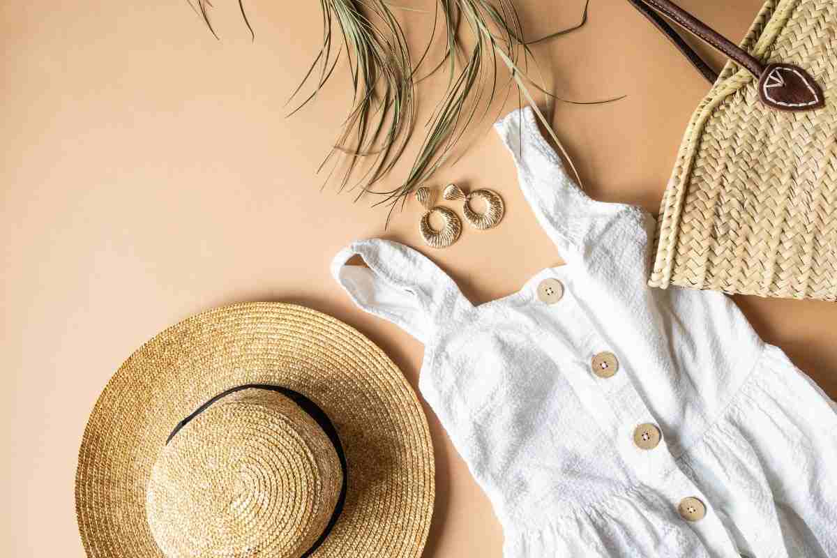vestito bianco, cappello di paglia e accessori vari